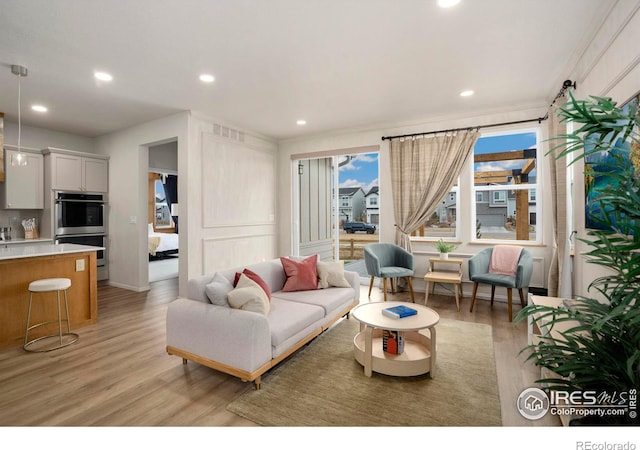 living room featuring light wood-style floors, recessed lighting, and visible vents