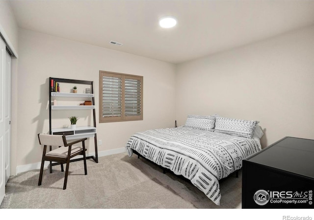 bedroom with carpet floors, baseboards, visible vents, and a closet