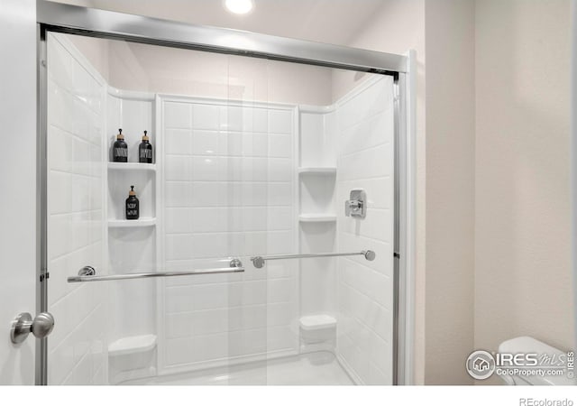 bathroom featuring a shower stall and toilet