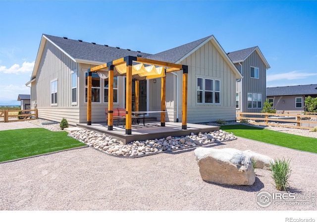 back of property with board and batten siding, a patio area, fence, and a shingled roof