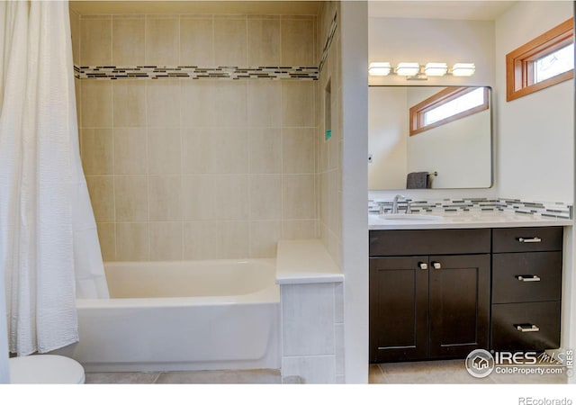 bathroom with shower / bathtub combination with curtain, vanity, and toilet