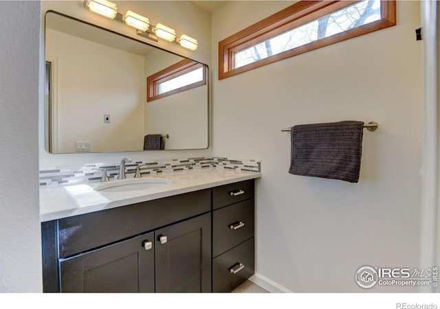 bathroom with backsplash, vanity, and baseboards