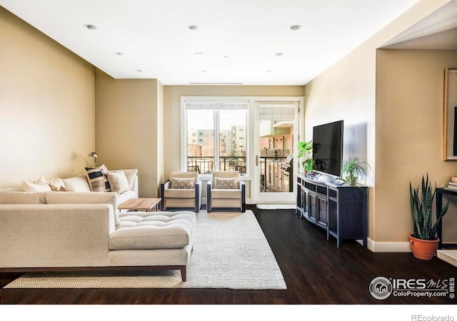 living area with dark wood-type flooring, recessed lighting, and baseboards