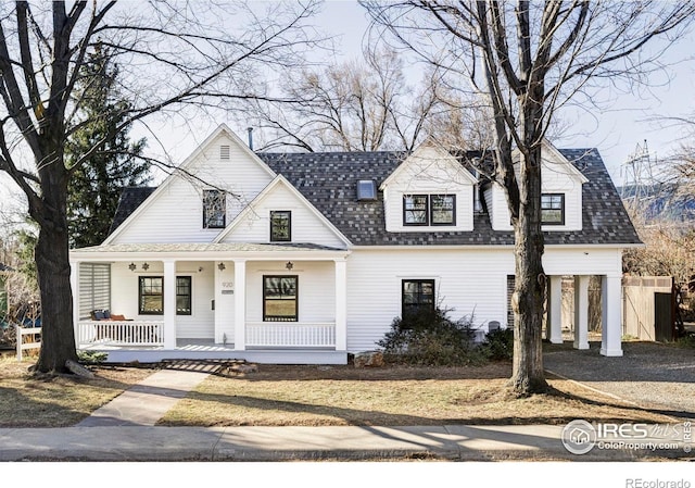 modern farmhouse featuring covered porch and a shingled roof