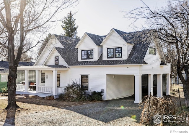 cape cod house featuring driveway, a porch, and a shingled roof