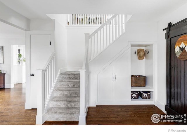 stairs with wood finished floors and a barn door