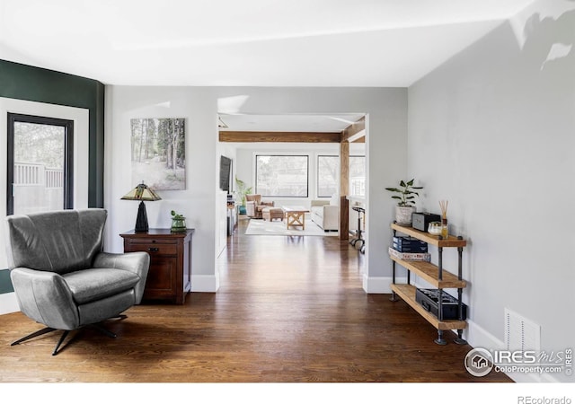 sitting room with wood finished floors, visible vents, and baseboards