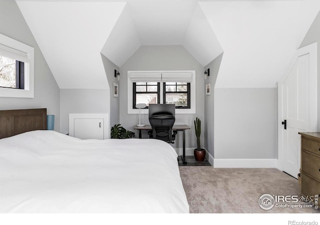 carpeted bedroom with lofted ceiling and baseboards