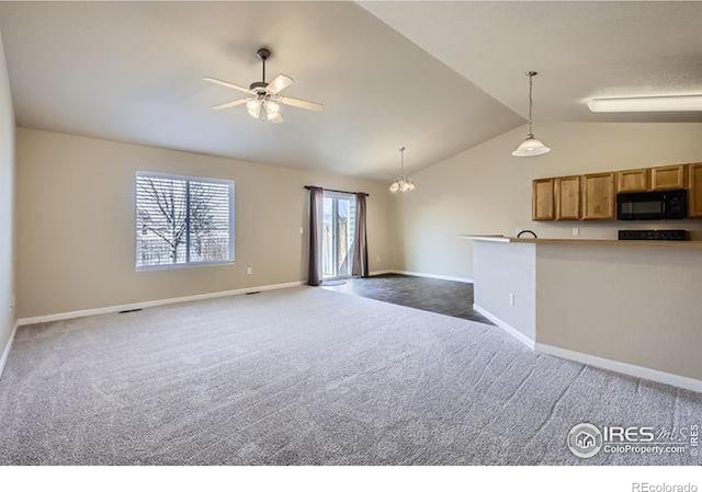 unfurnished living room featuring dark carpet, ceiling fan with notable chandelier, baseboards, and vaulted ceiling