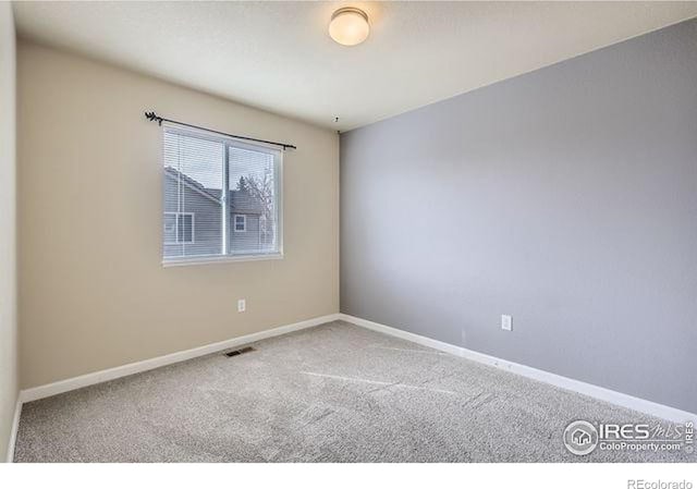 carpeted empty room featuring visible vents and baseboards