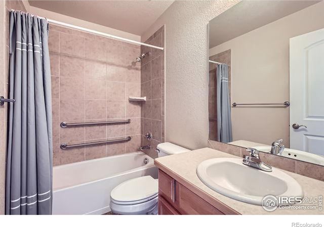 full bath featuring vanity, toilet, shower / tub combo, and a textured wall