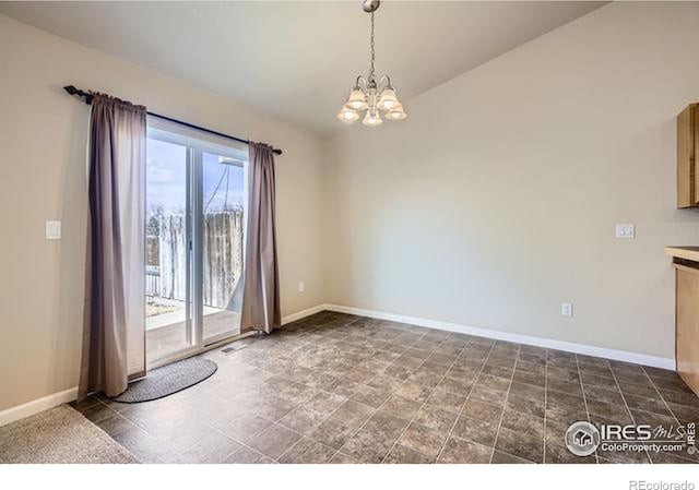 spare room featuring an inviting chandelier, baseboards, and lofted ceiling