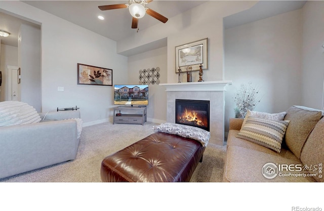 living room with carpet floors, recessed lighting, a ceiling fan, a tile fireplace, and baseboards