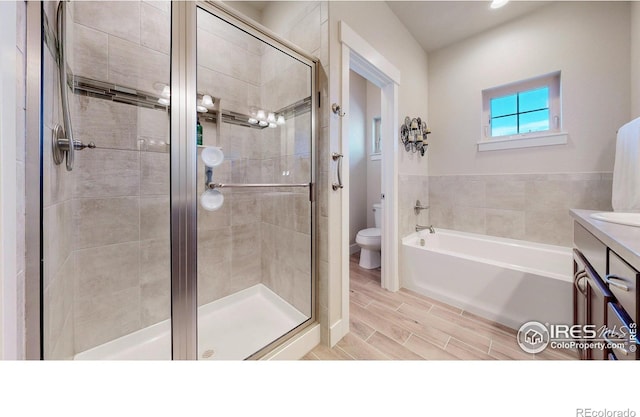 full bathroom with toilet, a shower stall, vanity, and wood finish floors