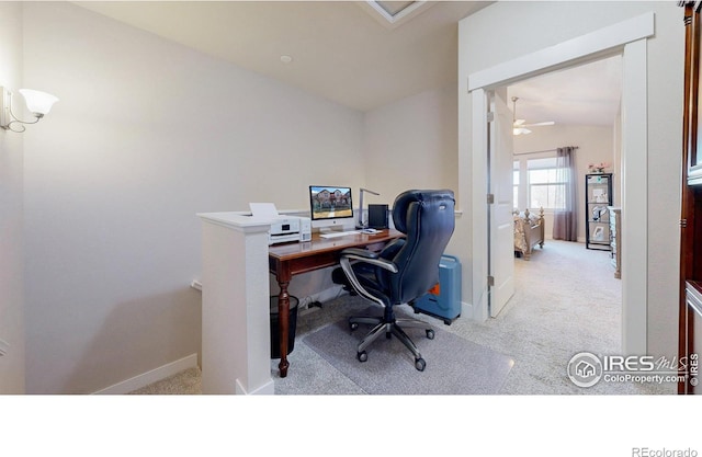 carpeted office space featuring lofted ceiling and baseboards