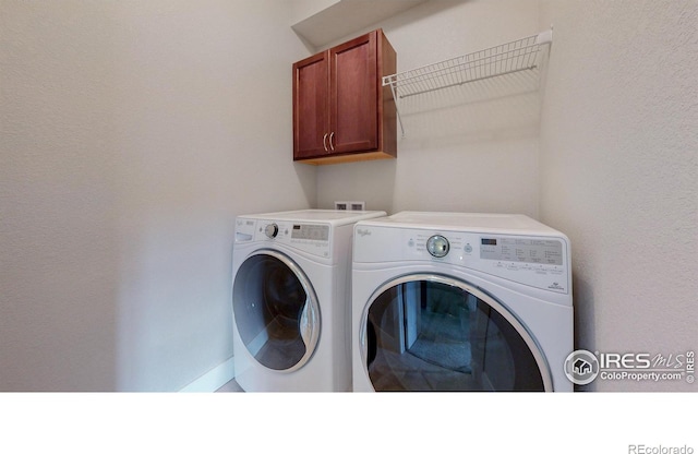 clothes washing area with cabinet space and washing machine and clothes dryer