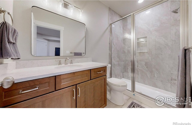 full bathroom with toilet, a stall shower, and vanity