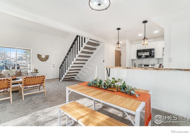 carpeted dining space with stairway