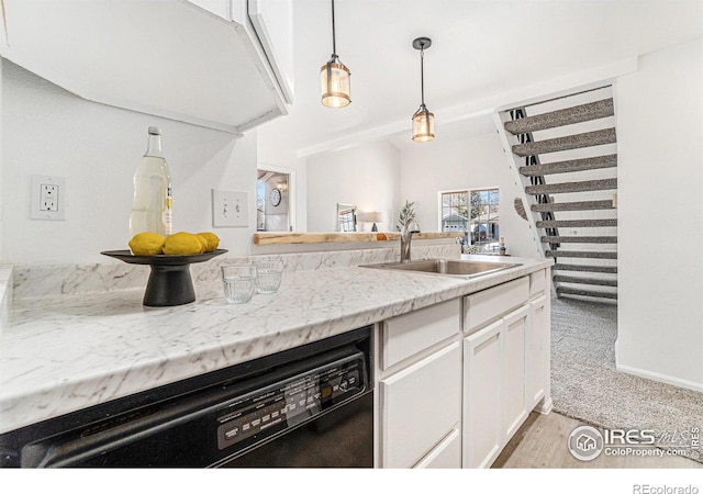 kitchen with decorative light fixtures, white cabinets, a sink, light stone countertops, and dishwasher