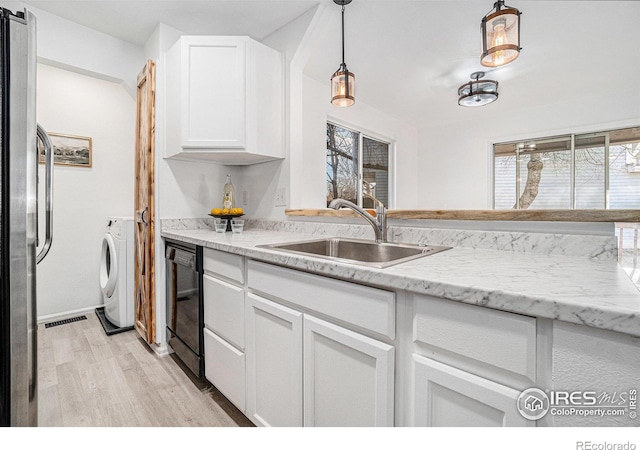 kitchen featuring washer / dryer, dishwasher, freestanding refrigerator, white cabinetry, and a sink