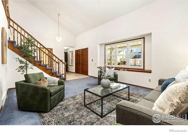 living room featuring carpet floors, high vaulted ceiling, baseboards, and stairs