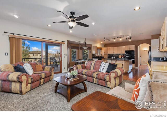 living room featuring arched walkways, wood finished floors, a ceiling fan, and recessed lighting