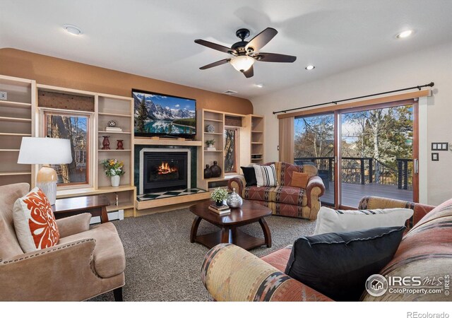 living area with ceiling fan, a lit fireplace, and recessed lighting