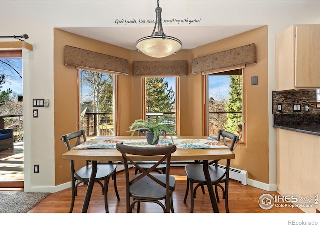 dining area with light wood finished floors, plenty of natural light, and baseboards