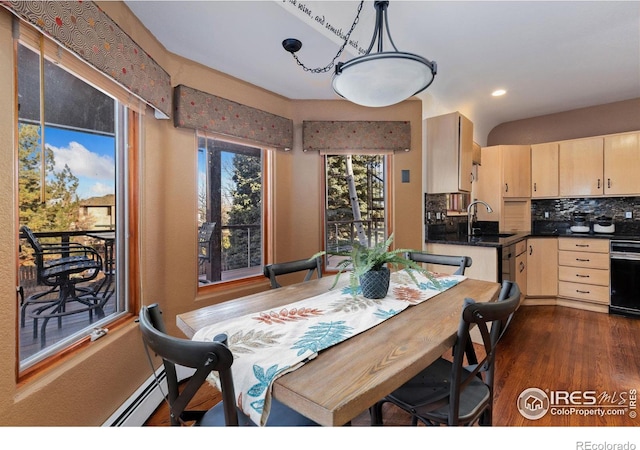 dining space with dark wood-style floors and a baseboard heating unit