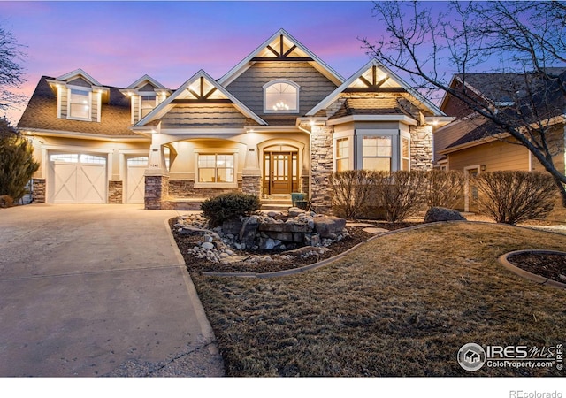 craftsman-style house with a garage, stone siding, concrete driveway, and stucco siding