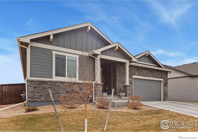 craftsman-style house featuring an attached garage, fence, stone siding, concrete driveway, and board and batten siding