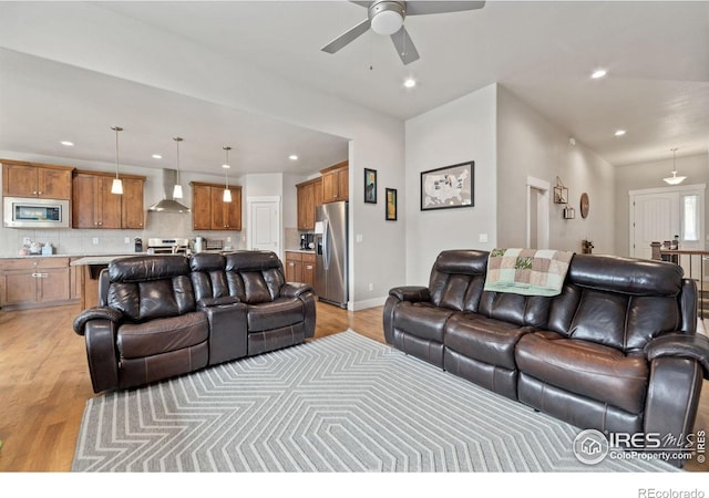 living room featuring ceiling fan, recessed lighting, baseboards, and light wood-style floors