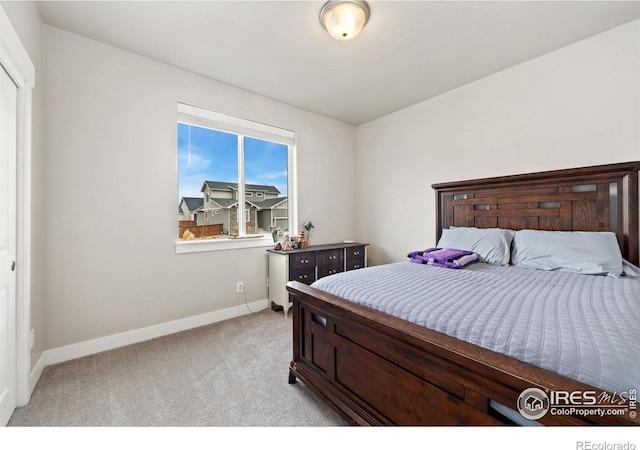 bedroom with light carpet and baseboards