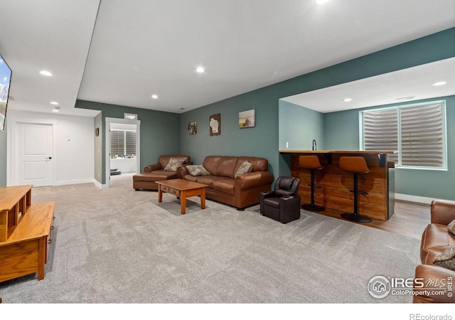 living area with carpet floors, wet bar, baseboards, and recessed lighting