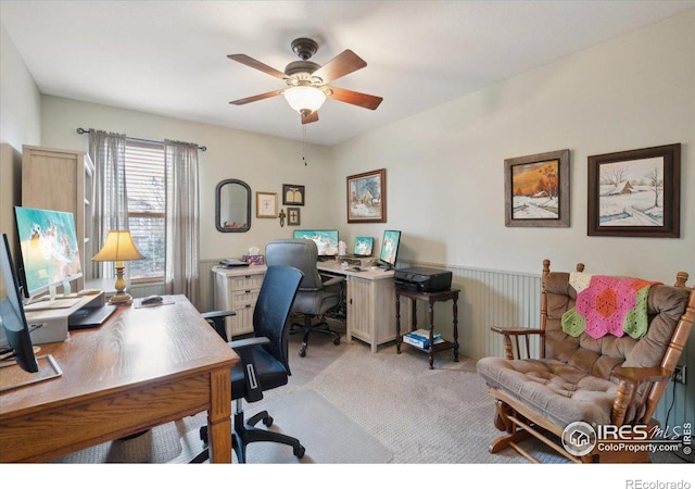 home office with ceiling fan, a wainscoted wall, and carpet flooring