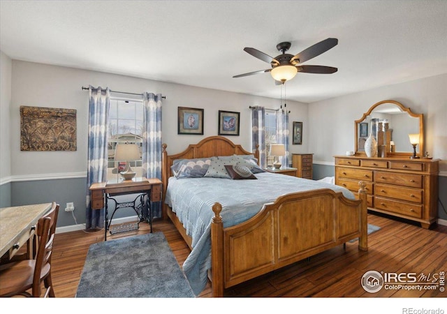 bedroom with ceiling fan, multiple windows, baseboards, and wood finished floors