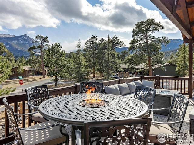 balcony featuring an outdoor living space with a fire pit, a mountain view, and outdoor dining space