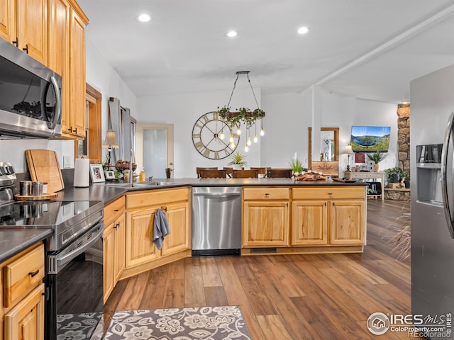 kitchen with a chandelier, appliances with stainless steel finishes, dark countertops, and wood finished floors