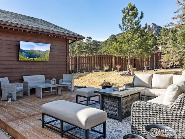 wooden deck featuring an outdoor living space with a fire pit and fence