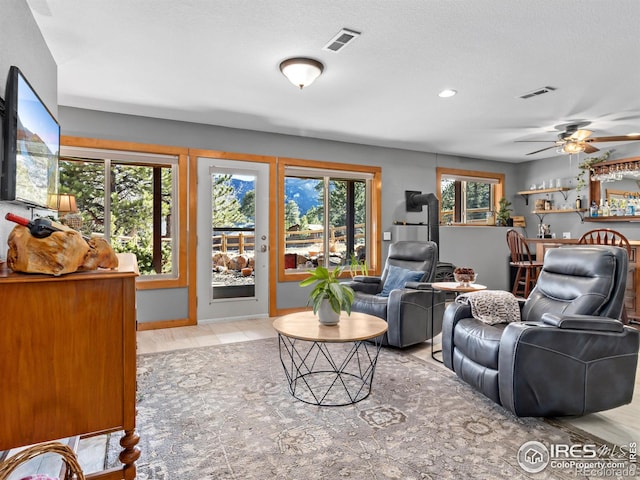 living room with baseboards, visible vents, bar area, and wood finished floors