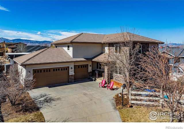 view of front of property with stucco siding, concrete driveway, a garage, stone siding, and a tiled roof