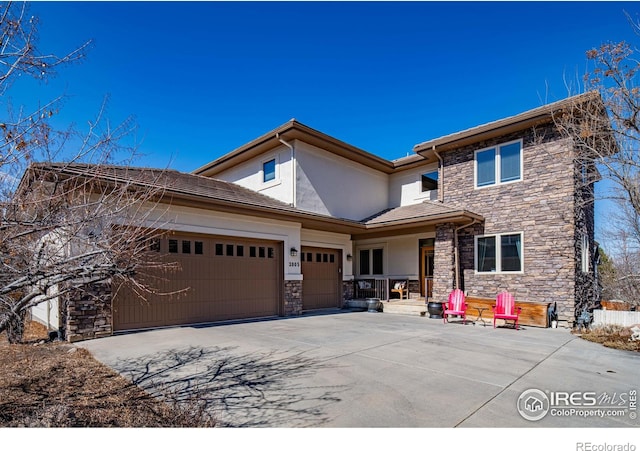 view of front of home with an attached garage, stone siding, concrete driveway, and stucco siding