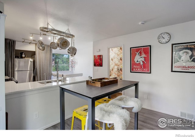 kitchen featuring visible vents, wood finished floors, and freestanding refrigerator