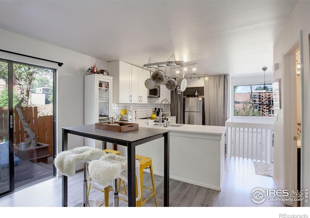 kitchen with a chandelier, stainless steel appliances, tasteful backsplash, and a peninsula