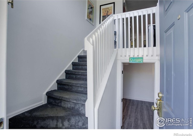 stairway featuring wood finished floors and baseboards