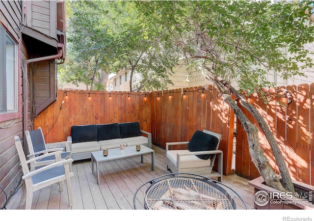 deck featuring outdoor dining area, a fenced backyard, and an outdoor hangout area