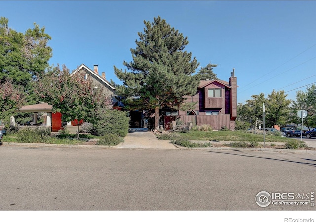 view of front of property featuring a chimney and fence