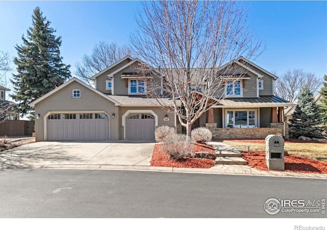 craftsman-style home with metal roof, an attached garage, covered porch, concrete driveway, and a standing seam roof