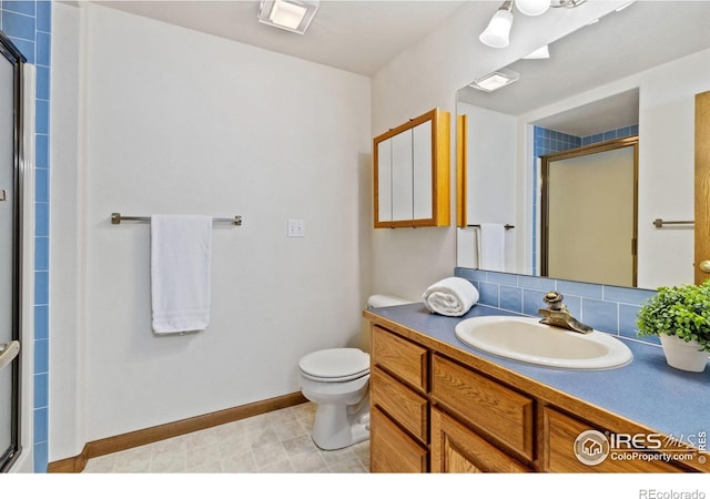 bathroom with toilet, vanity, baseboards, tasteful backsplash, and a stall shower