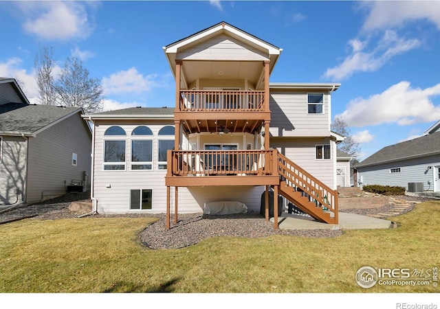 back of property with stairway, a lawn, and a balcony